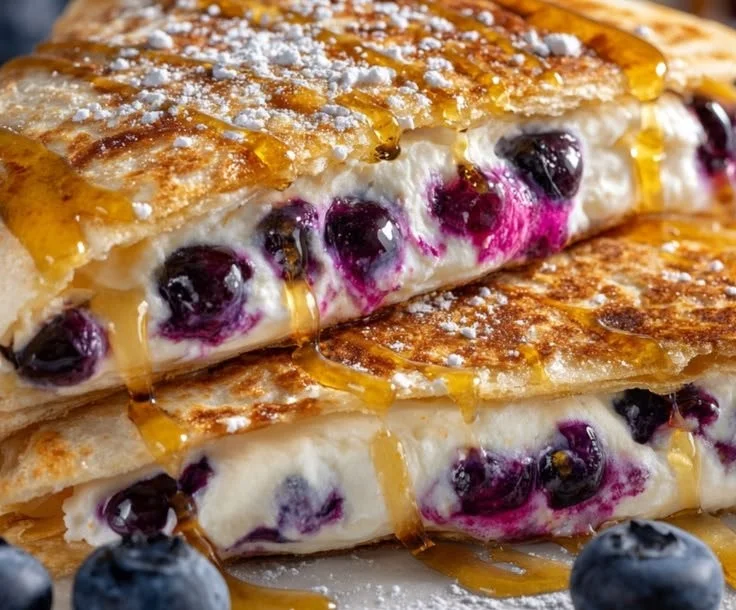 Blueberry quesadilla served on a plate, showcasing melted cheese and fresh blueberries.