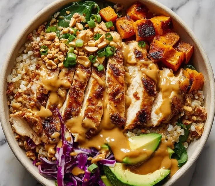 Peanut chicken protein bowls topped with colorful vegetables and crunchy peanuts