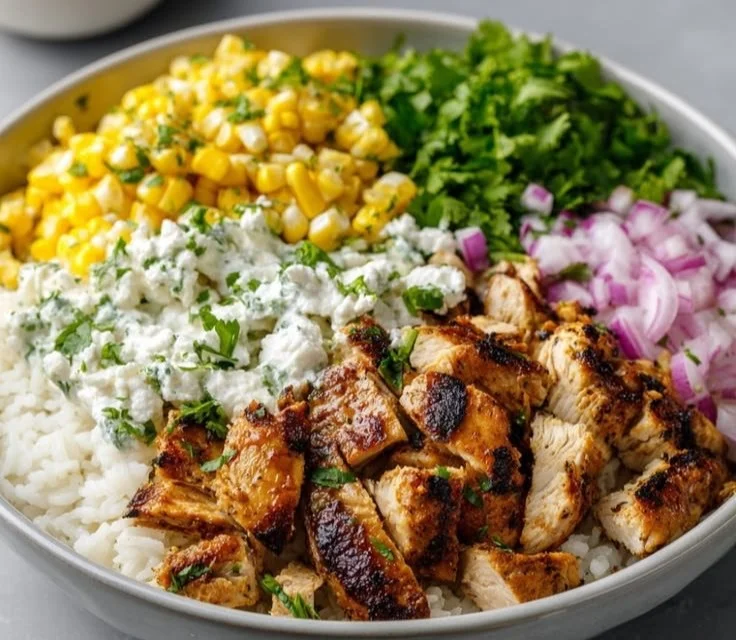Bowl of grilled chicken with cilantro lime rice and Mexican street corn salad