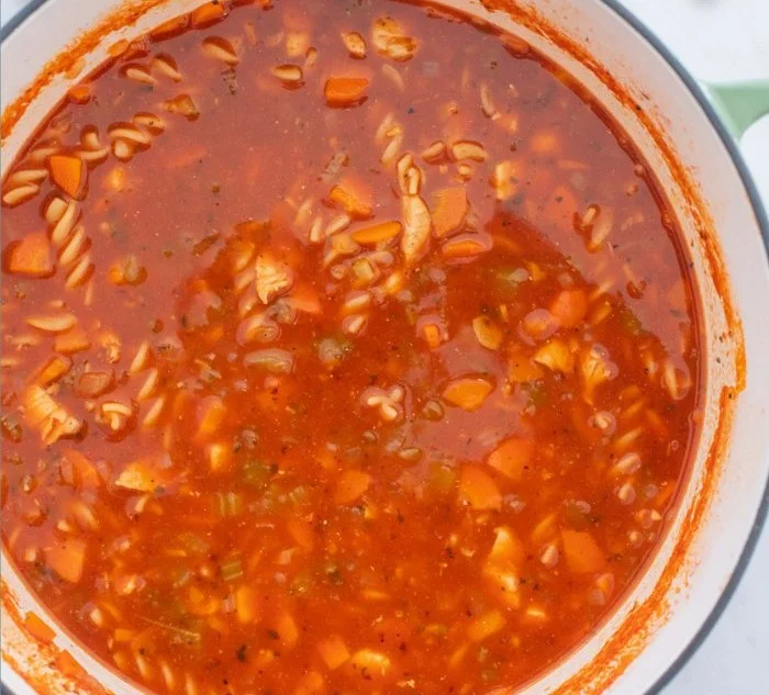 Delicious bowl of Chicken Parmesan Soup garnished with cheese and herbs