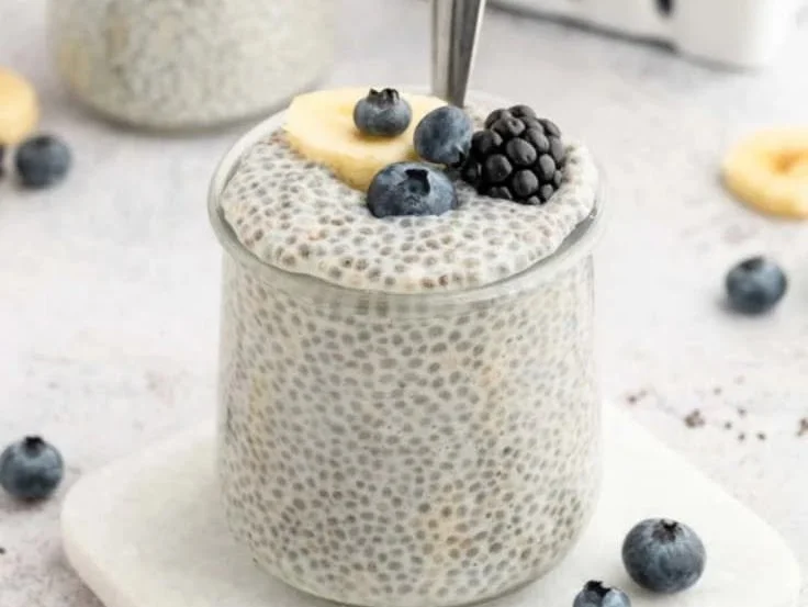 Bowl of creamy vanilla chia pudding topped with fresh berries and nuts