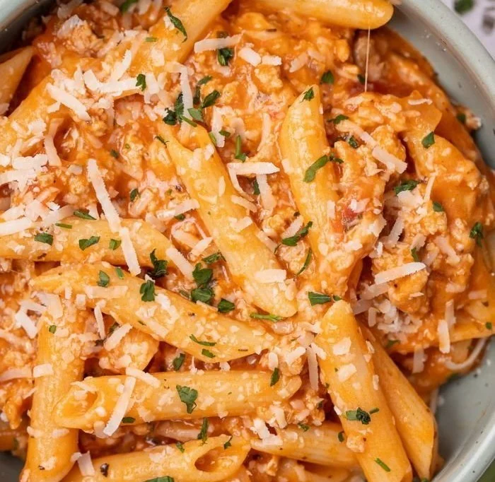 Healthy ground turkey pasta dish served in a bowl with herbs and vegetables