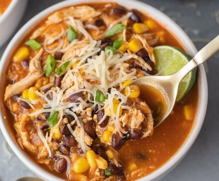 Bowl of healthy chicken taco soup garnished with cilantro and lime