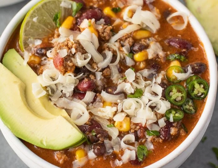 Bowl of healthy taco soup topped with cheese and cilantro