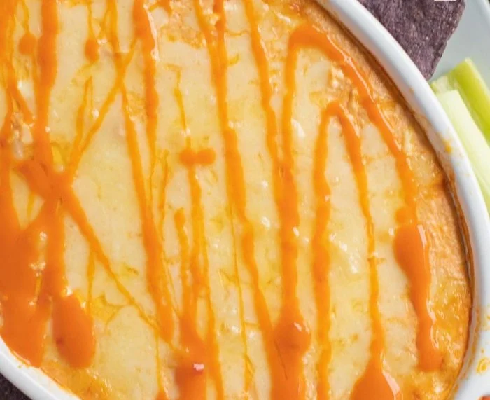 High protein buffalo chicken dip served in a bowl with tortilla chips.