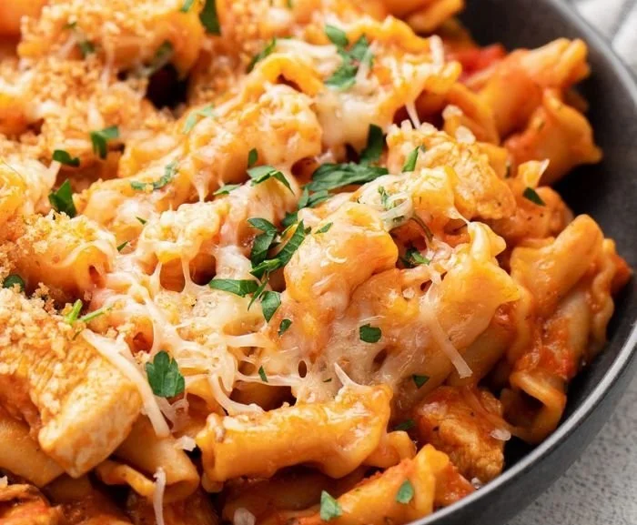 High protein chicken parm pasta dish served with cheese and herbs