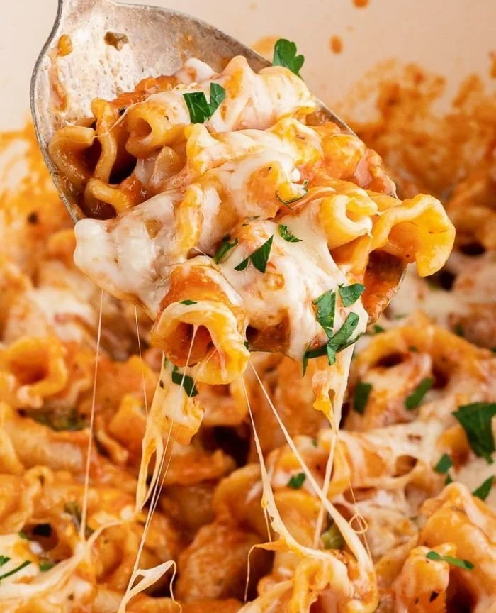 Delicious high protein chicken parmesan pasta topped with cheese and herbs