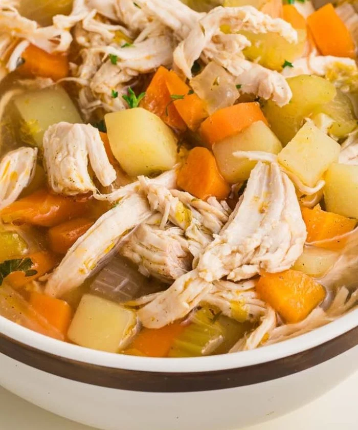 Bowl of high protein chicken potato soup with vegetables and herbs