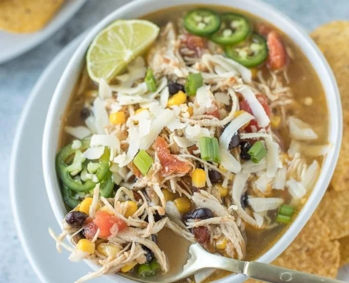 Bowl of high protein chicken tortilla soup garnished with tortilla strips and cilantro
