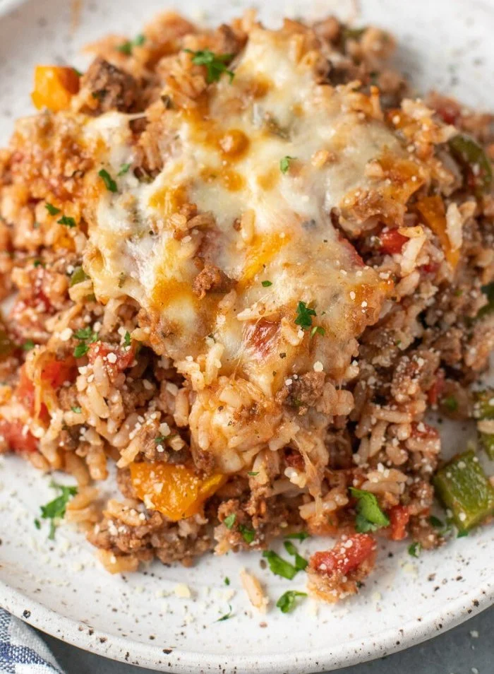 High protein stuffed pepper casserole topped with herbs and colorful peppers