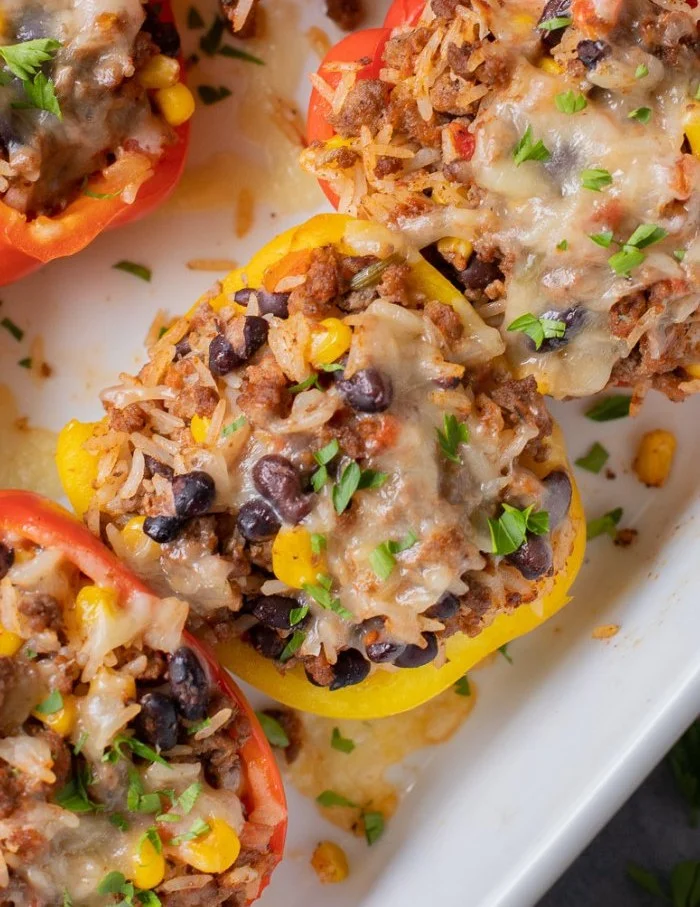 Taco stuffed peppers filled with rice and topped with cheese on a plate