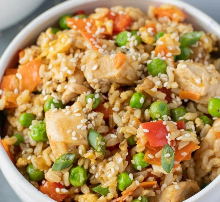 Plate of healthy fried rice with chicken and colorful vegetables